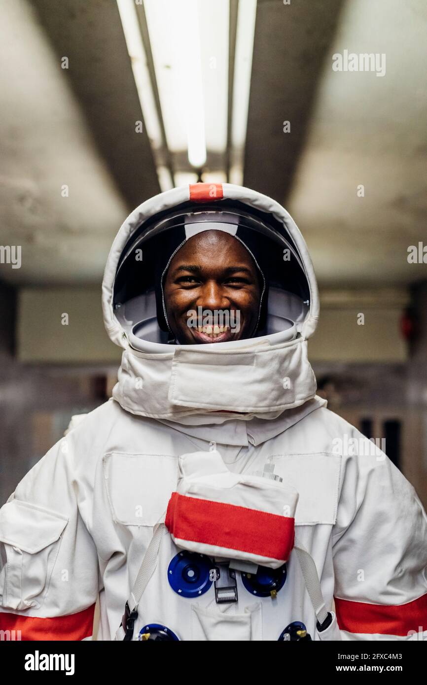 Lächelnder männlicher Astronaut im Keller Stockfoto