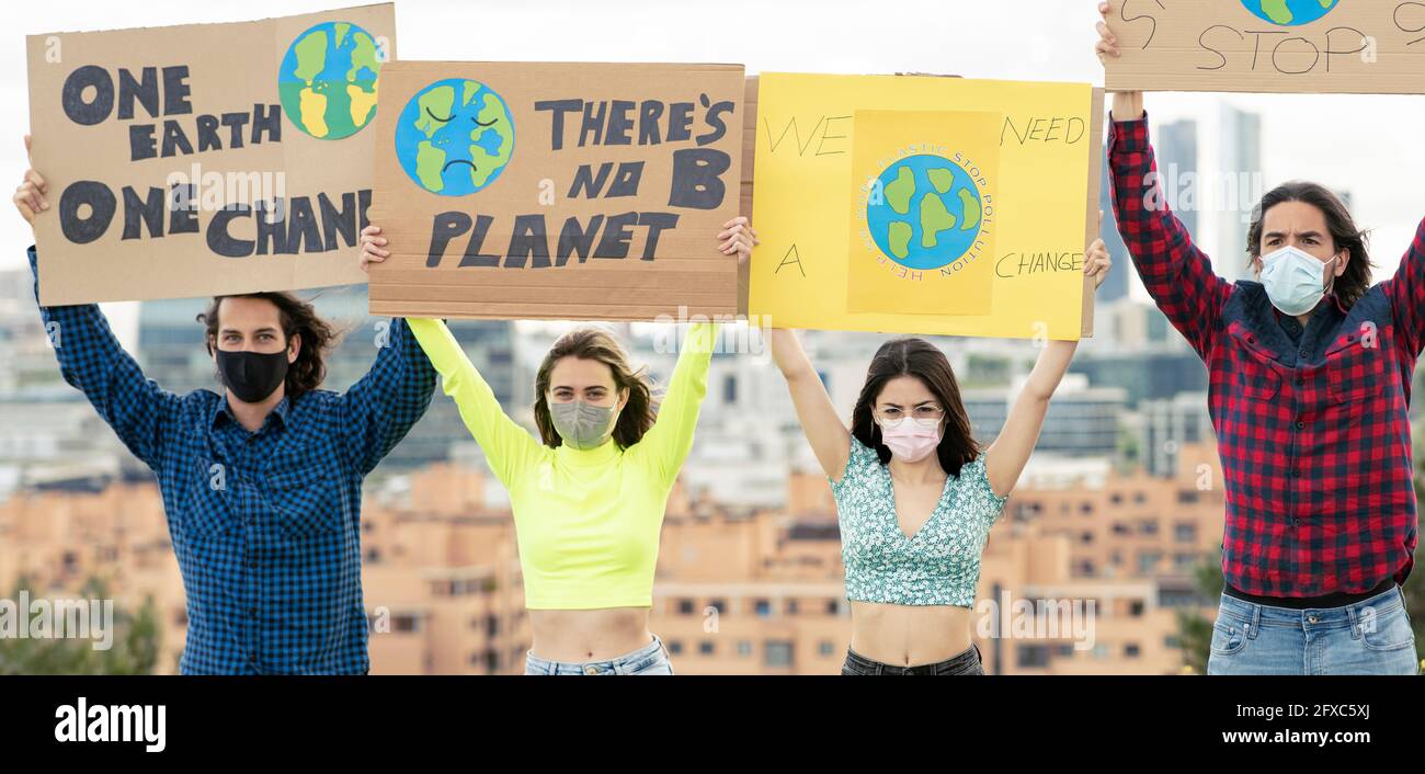 Aktivist steht mit einem Plakat zur Wachsamkeit des Klimawandels Stockfoto