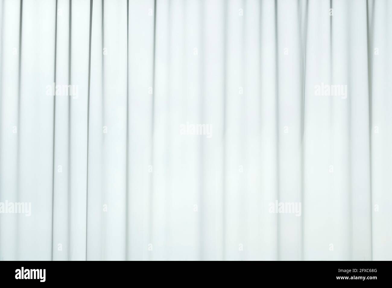 Licht, das durch transparente, plissierte weiße Vorhänge oder Vorhänge kommt. Gestreifte, vertikale lineare Muster. Abstrakter Vollformat-Hintergrund. Stockfoto
