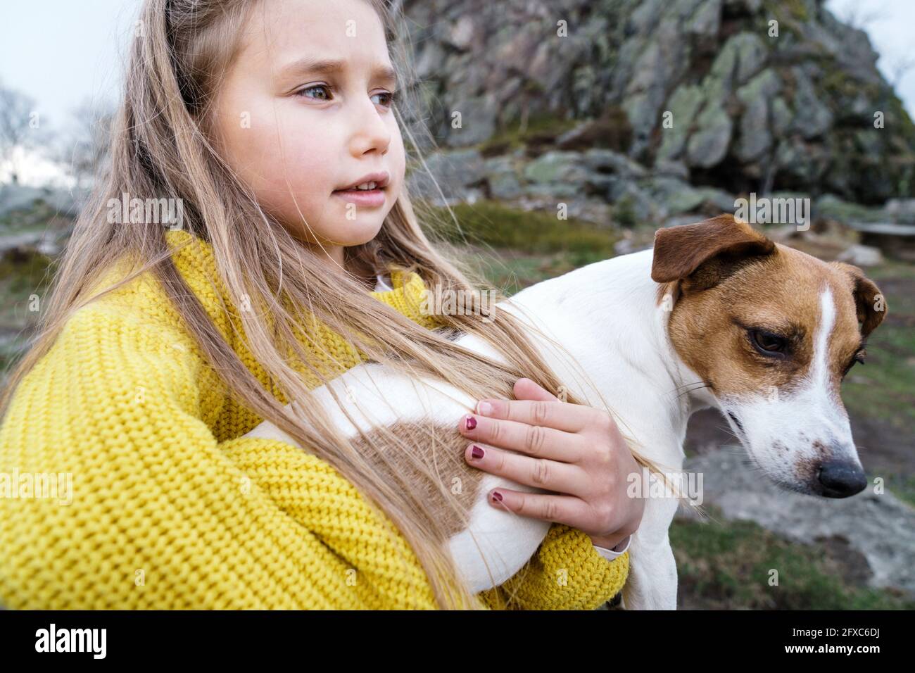 Blonde Mädchen trägt Jack Russell Terrier weg schauen Stockfoto