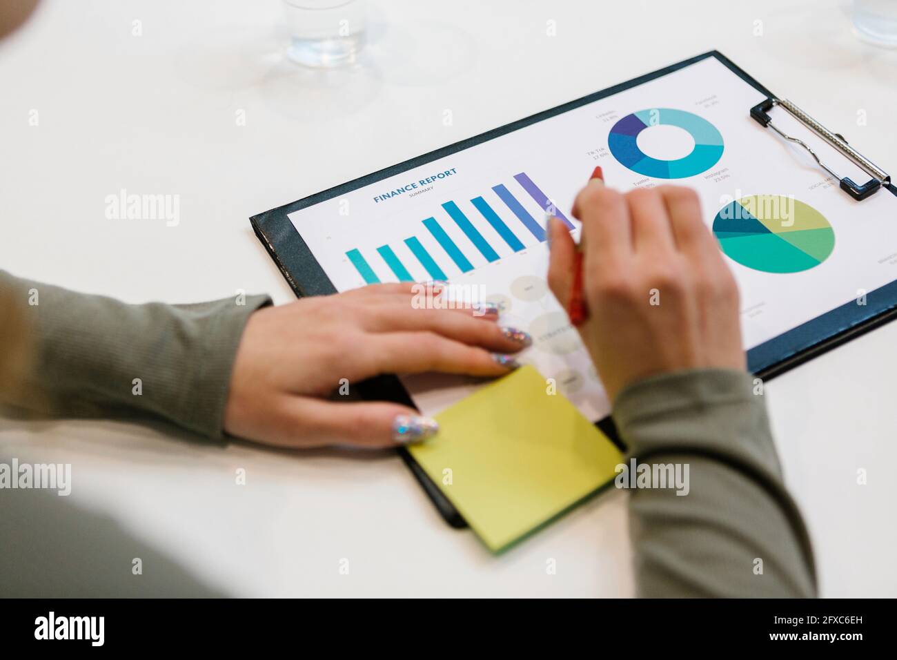 Junge Geschäftsfrau, die am Schreibtisch im Büro an einem Finanzbericht arbeitet Stockfoto