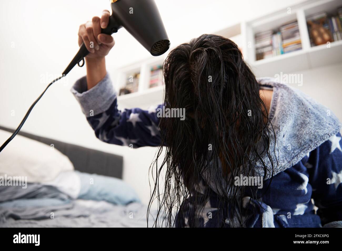 Frau, die zu Hause einen Haartrockner benutzt Stockfoto
