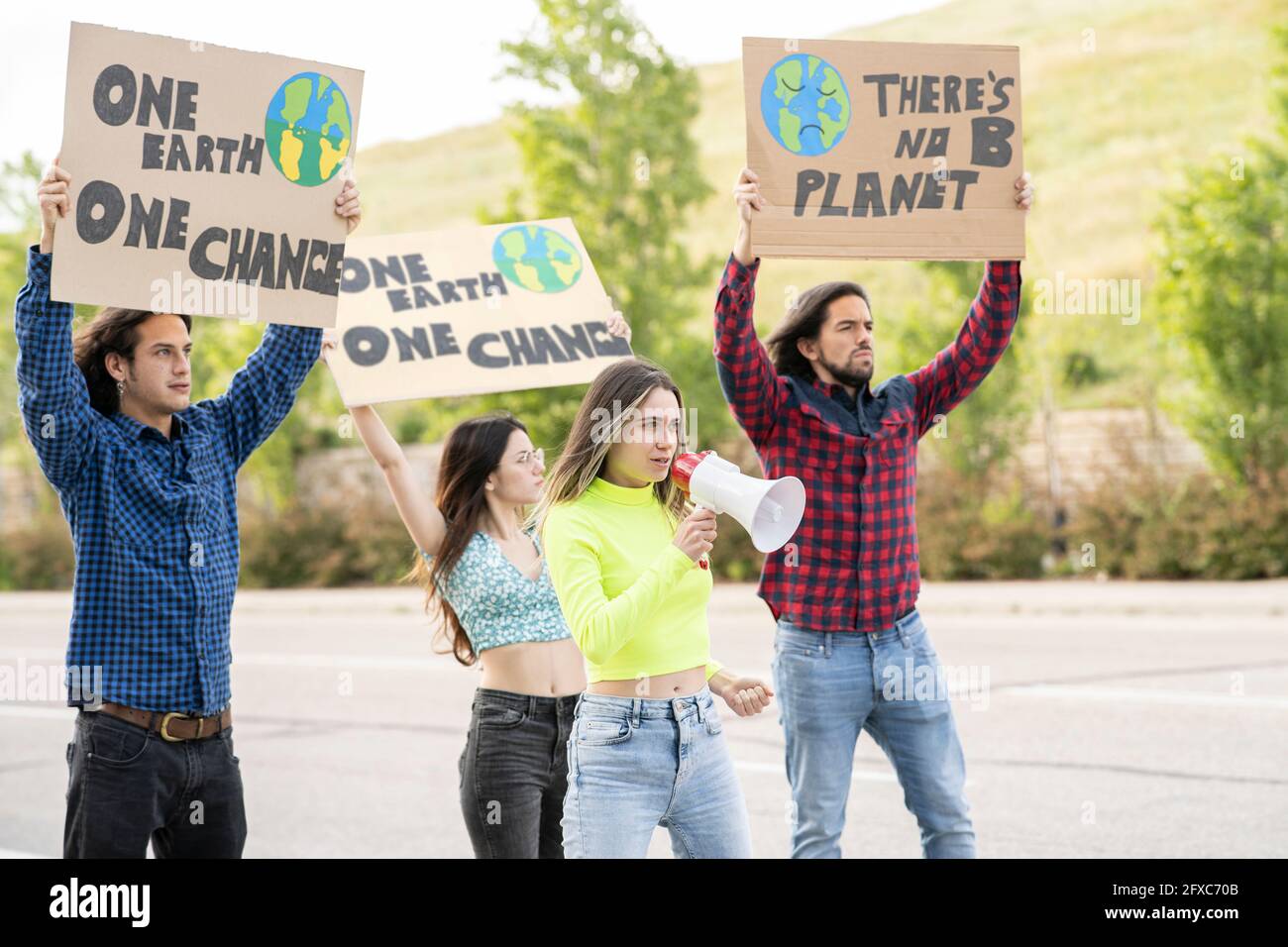 Wütender Aktivist, der gegen den Klimawandel protestiert, mit männlichen und weiblichen Demonstranten auf dem Weg zum Klimawandel Stockfoto