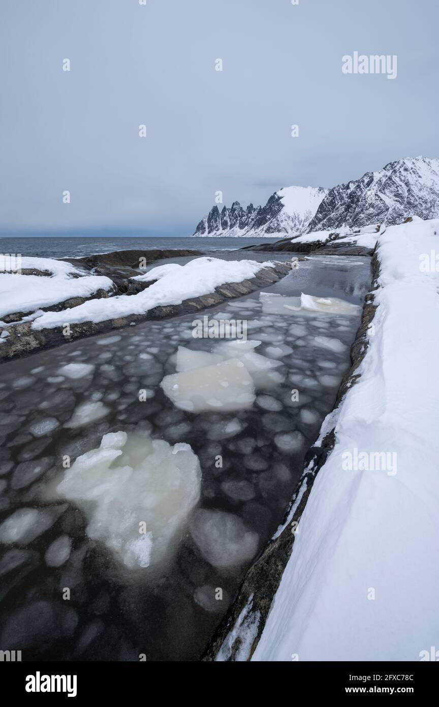 Norwegen, Tromso, Ersfjord, Eisbrocken im Wasser entlang der Küste der Insel Senja Stockfoto