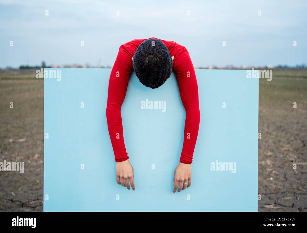 Frau, die sich auf blaues Gemälde stützt Stockfoto