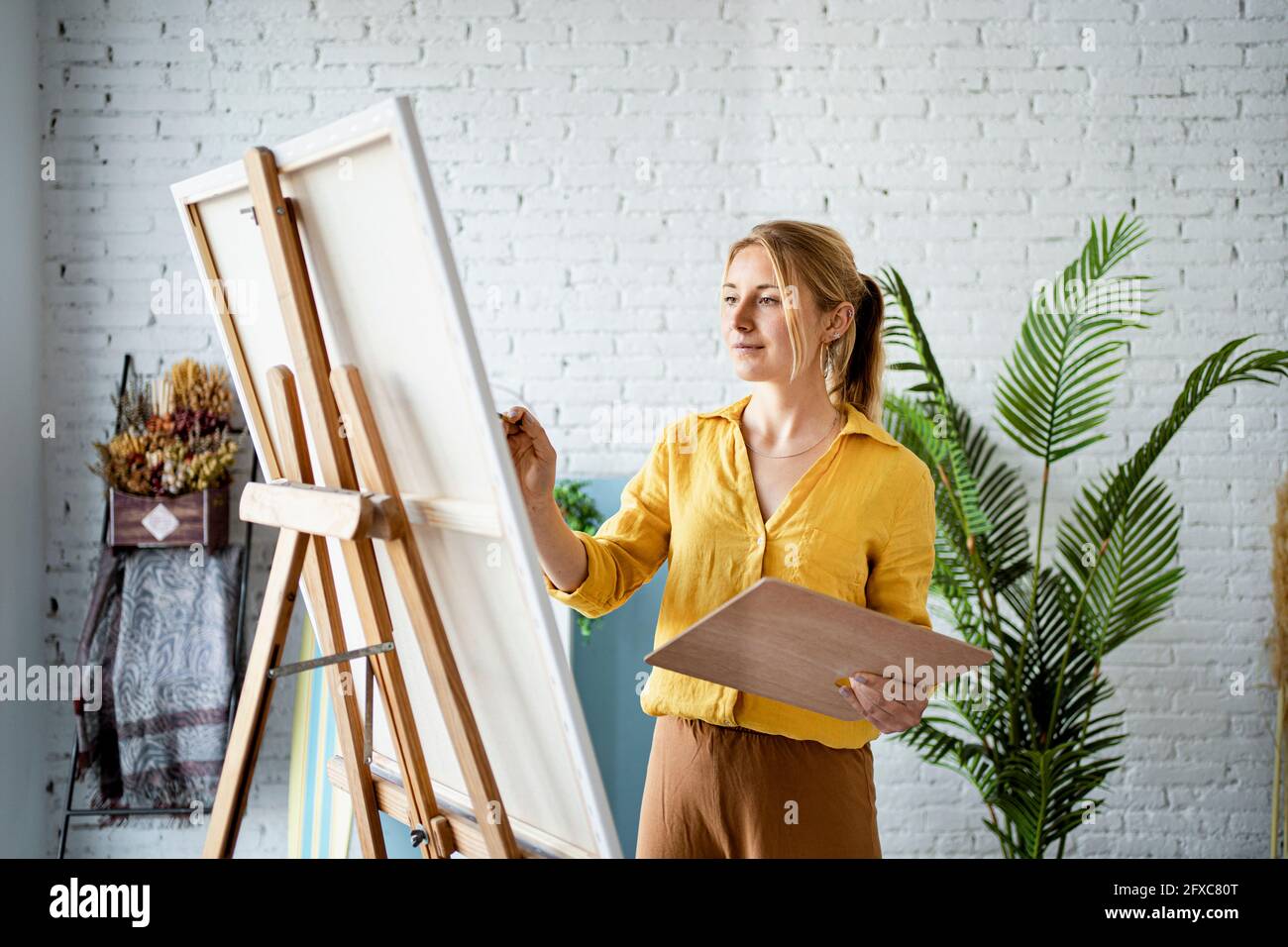 Frau in legerer Kleidung zu Hause malen Stockfoto