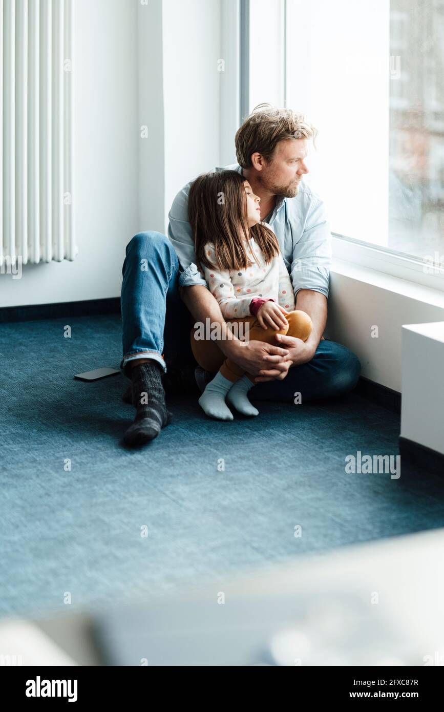 Vater und Tochter träumen zu Hause am Fenster Stockfoto