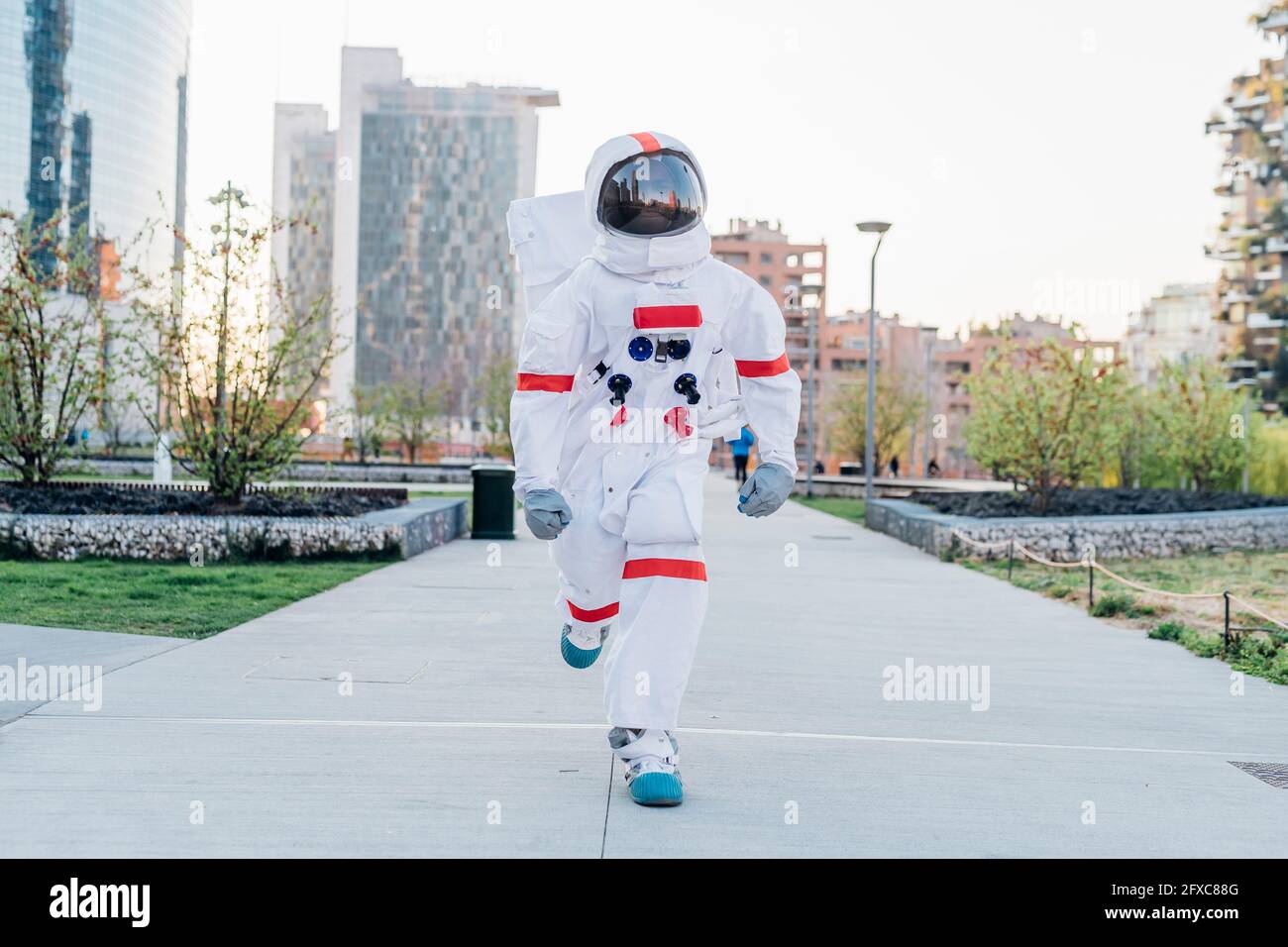 Männlicher Astronaut, der im öffentlichen Park läuft Stockfoto