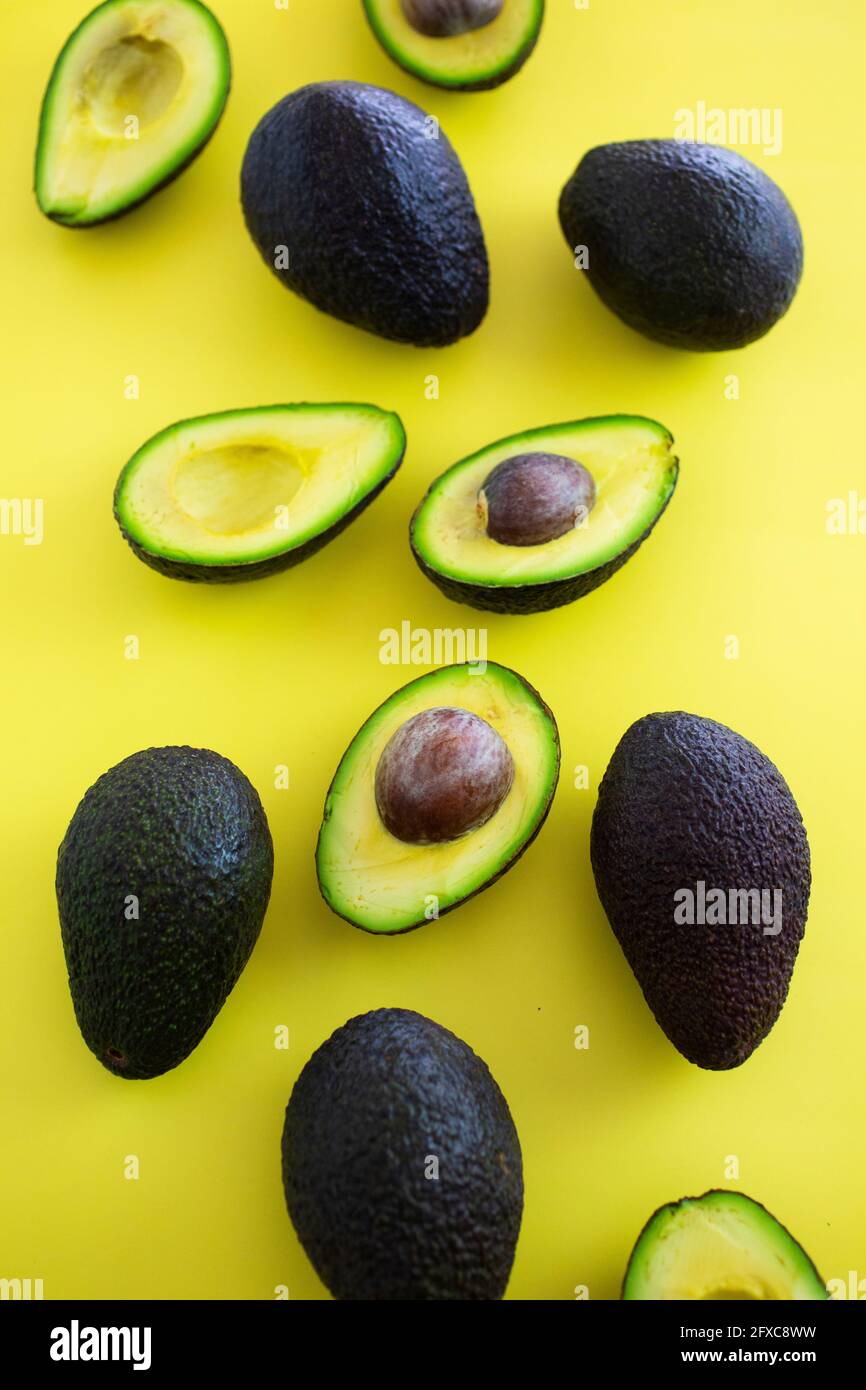 Studioaufnahme von halbierten und ganzen Avocados Stockfoto
