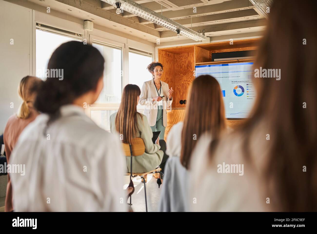 Weibliche Unternehmerin, die bei einer Konferenzveranstaltung vor Kollegen vorgeführt wird Stockfoto