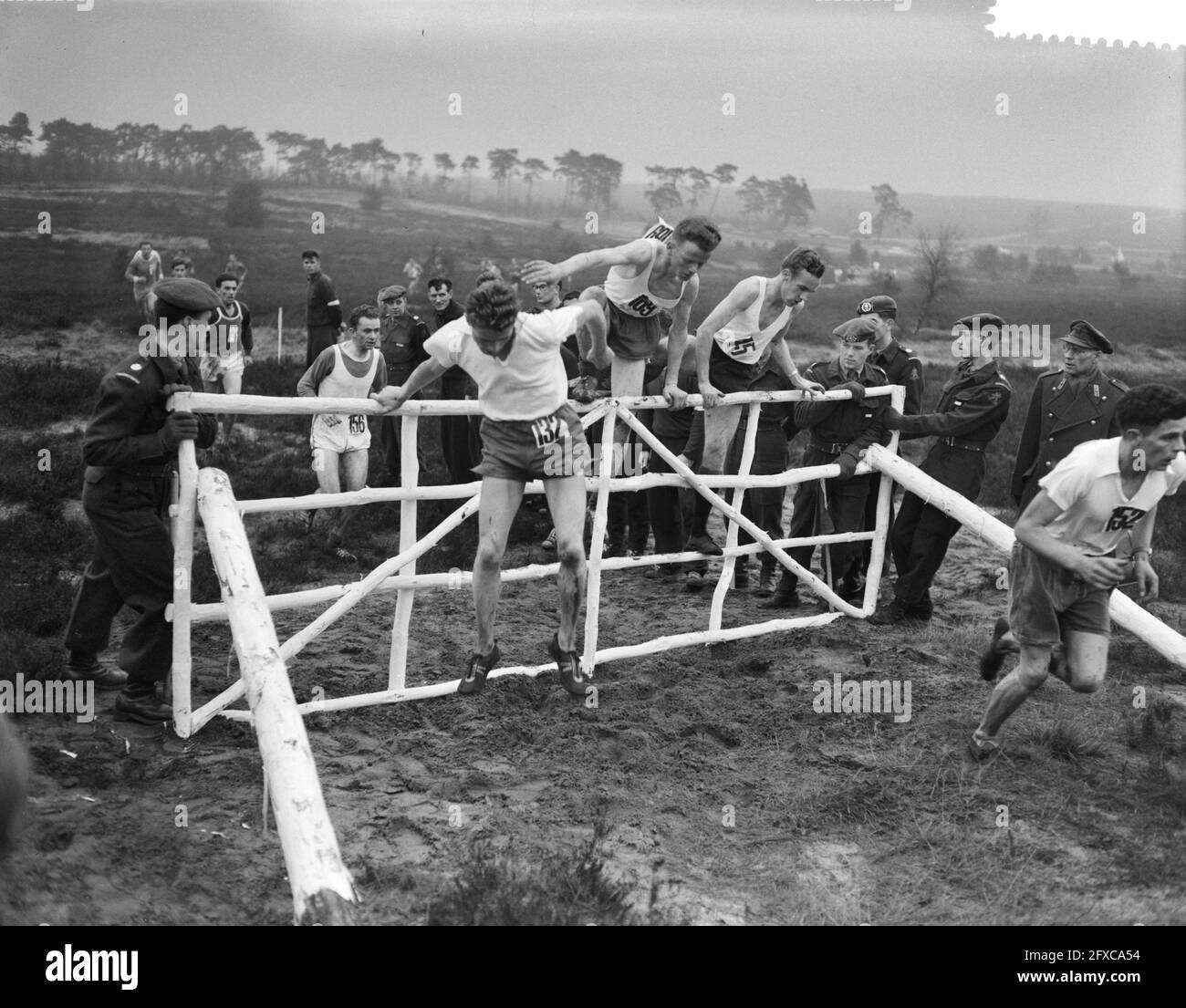 Nationale militärische Cross-Country-Meisterschaft bei Ede Teilnehmer nehmen Hürde, 17. Dezember 1958, Teilnehmer, Niederlande, 20. Jahrhundert Presseagentur Foto, Nachrichten zu erinnern, Dokumentarfilm, historische Fotografie 1945-1990, visuelle Geschichten, Menschliche Geschichte des zwanzigsten Jahrhunderts, Momente in der Zeit festzuhalten Stockfoto