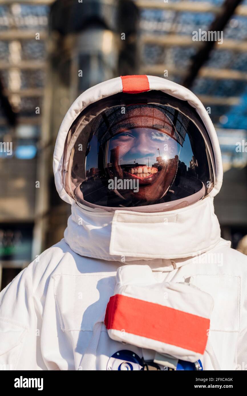 Glücklicher männlicher Astronaut mit Weltraumanzug in der Stadt Stockfoto