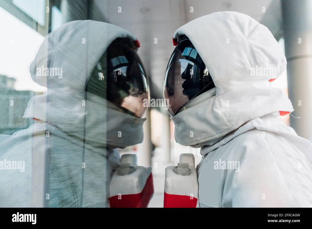 Astronaut mittleren Erwachsenen mit Blick auf die Glaswand Stockfoto