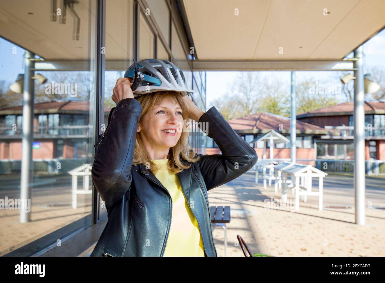 Lächelnde Frau mit Sporthelm an sonnigen Tagen Stockfoto