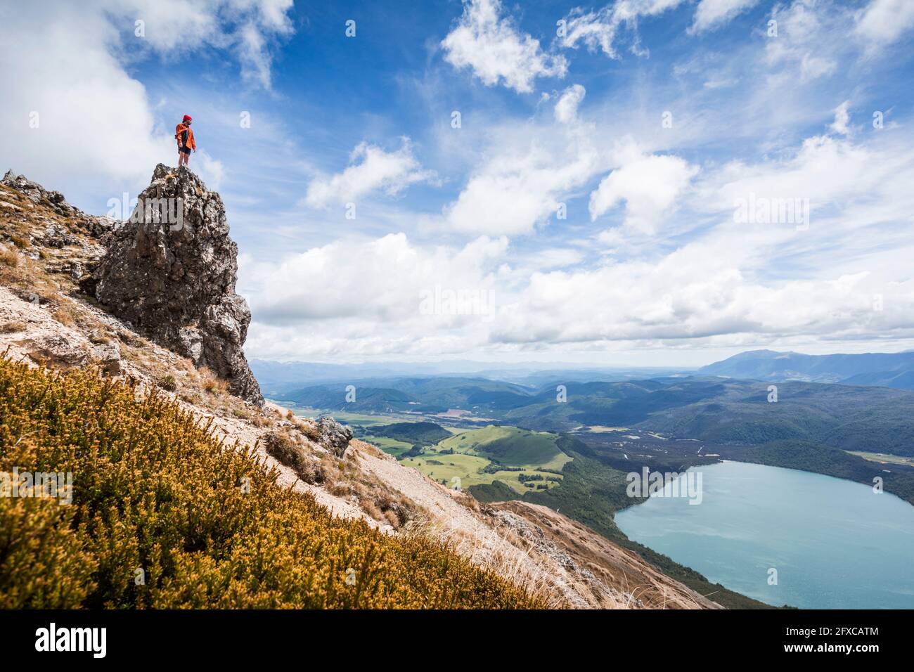 Neuseeland, Tasman District, männlicher Wanderer, der auf einer Felsformation mit Blick auf den scenicÂ Lake Rotoiti steht Stockfoto