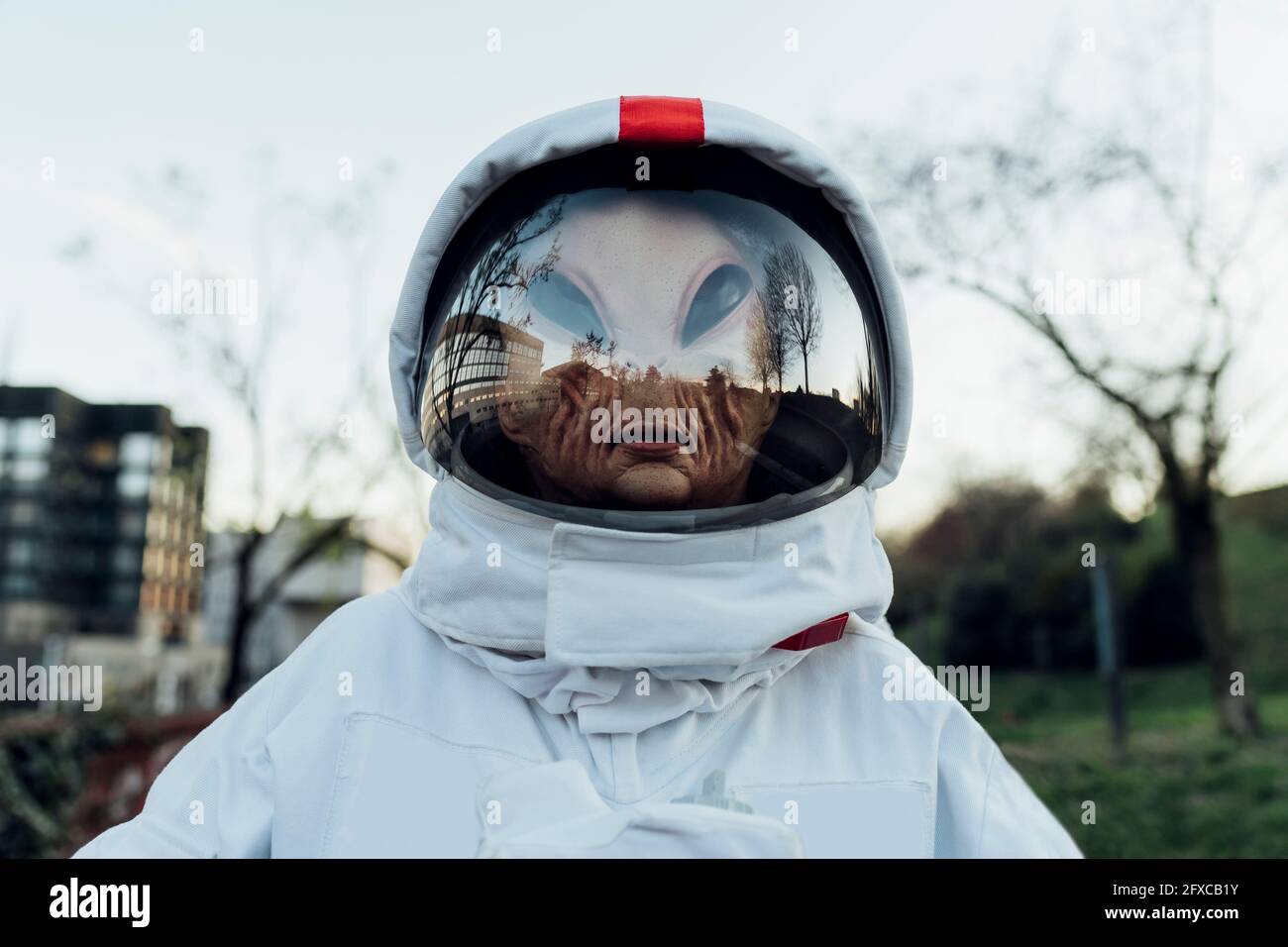 Frau Astronautin mit Alien-Maske im Freien stehen Stockfoto