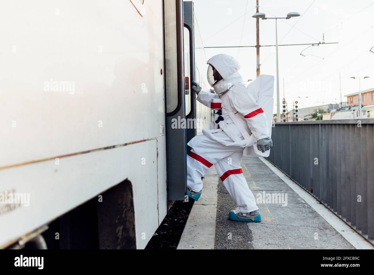 Weibliche Astronautin mit Raumanzug beim Bahnhofseingang Stockfoto