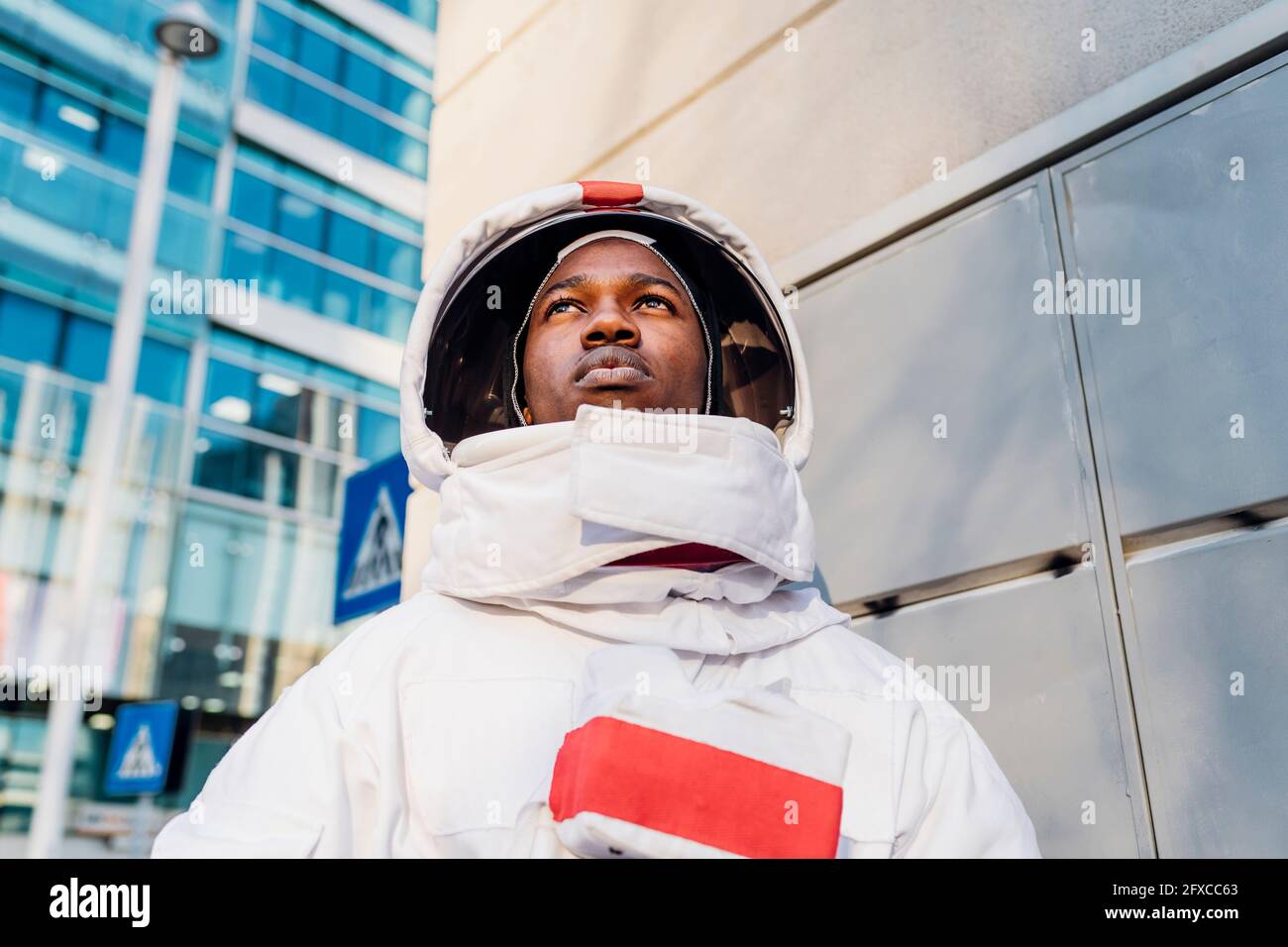 Männlicher Astronaut schaut weg, während er die Stadt erkundet Stockfoto