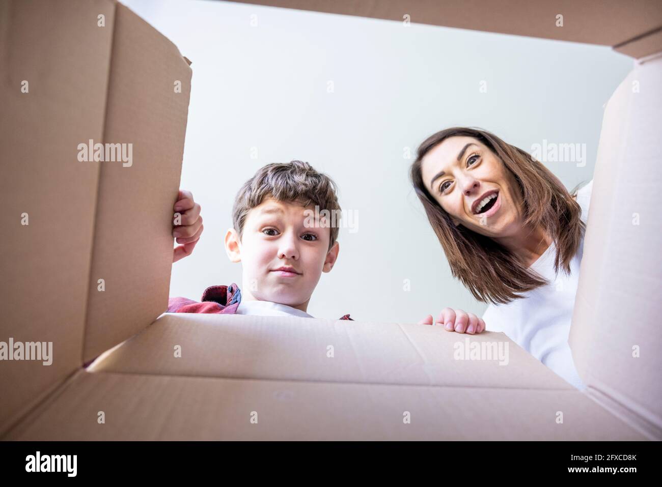 Überraschte Mutter und Sohn beim Blick in die Box Stockfoto