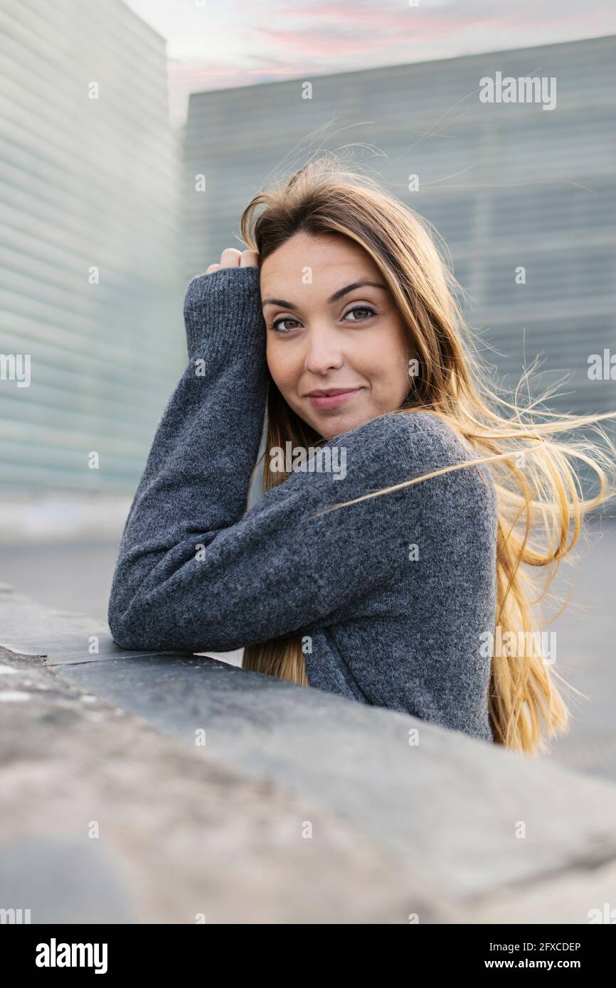 Schöne Frau lächelt an der Stützmauer Stockfoto