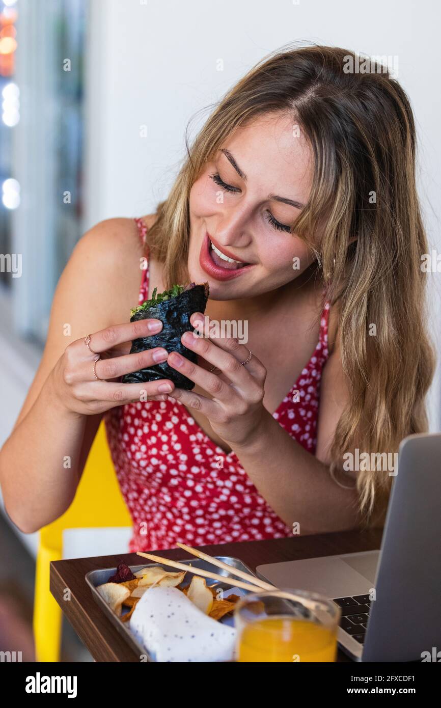 Junge Frau beim Essen im Restaurant Stockfoto