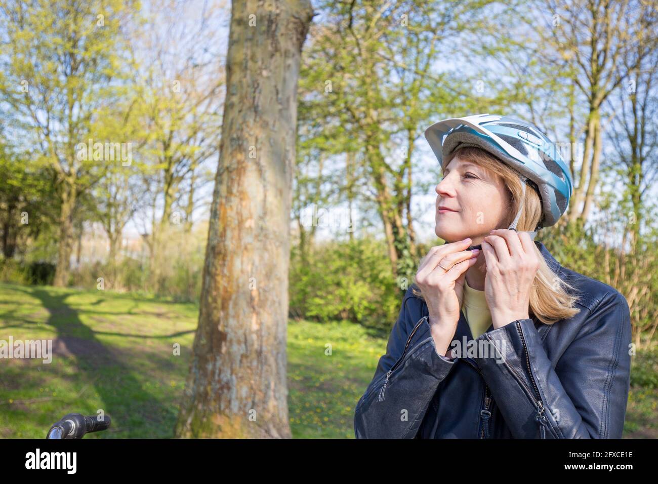 Reife Frau Befestigung Helmband von Baum Stockfoto