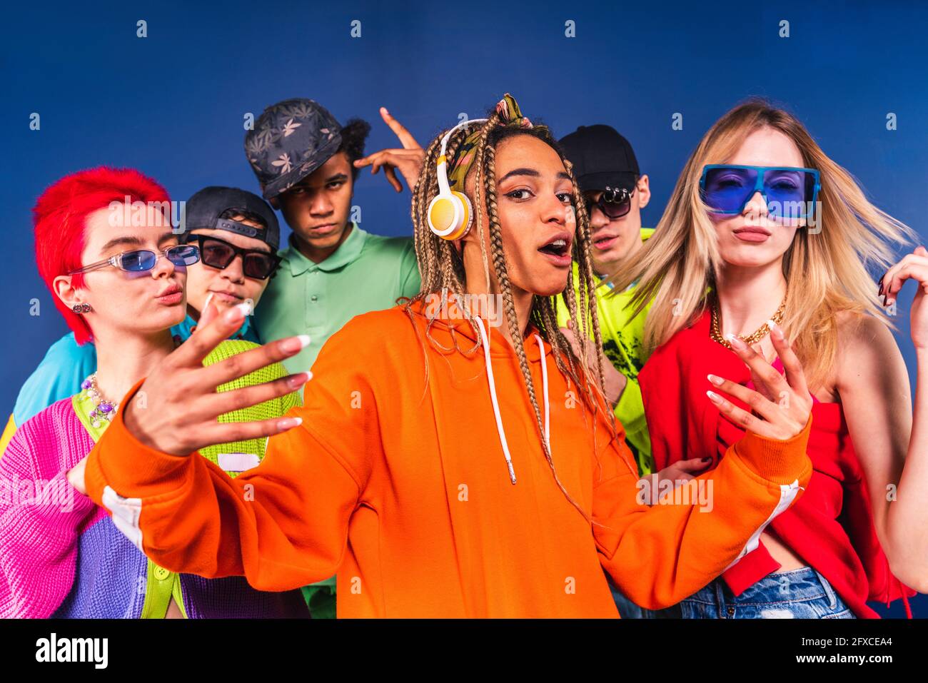 Coole Freunde tanzen vor blauem Hintergrund zusammen Stockfoto