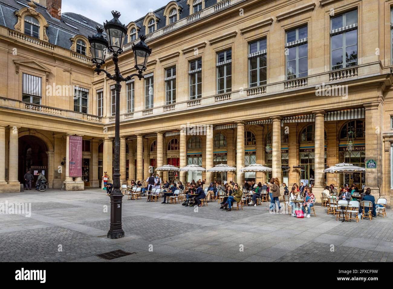 Paris, Frankreich - 25. Mai 2021: Tag nach der Sperre wegen Covid-19 in einem berühmten Pariser Café. Die Kellner tragen chirurgische Masken Stockfoto