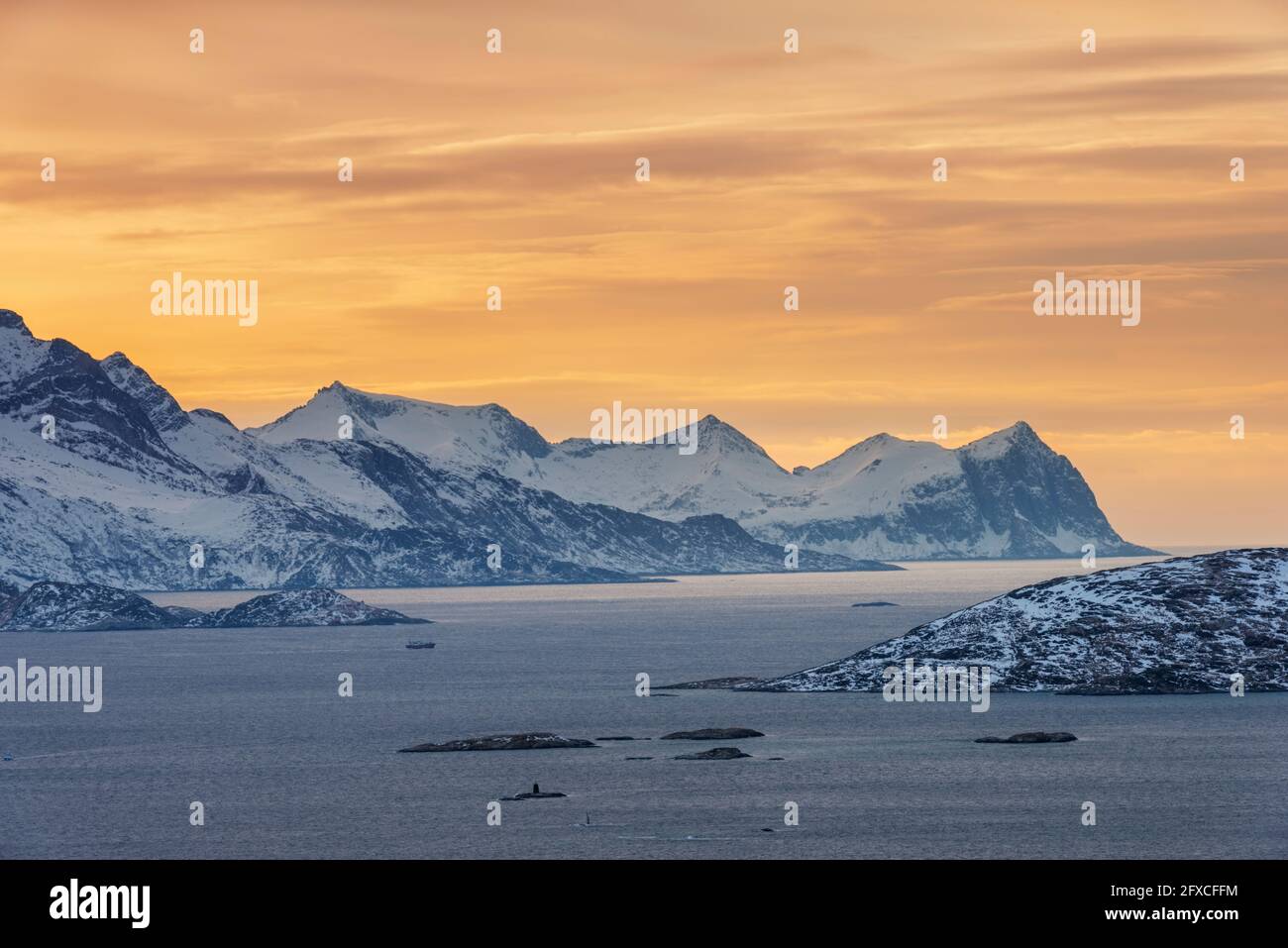 Norwegen, Tromso, Kvaloya, dramatischer Himmel über dem verschneiten Berg Senja Island bei Sonnenuntergang von der Insel Kvaloya aus gesehen Stockfoto