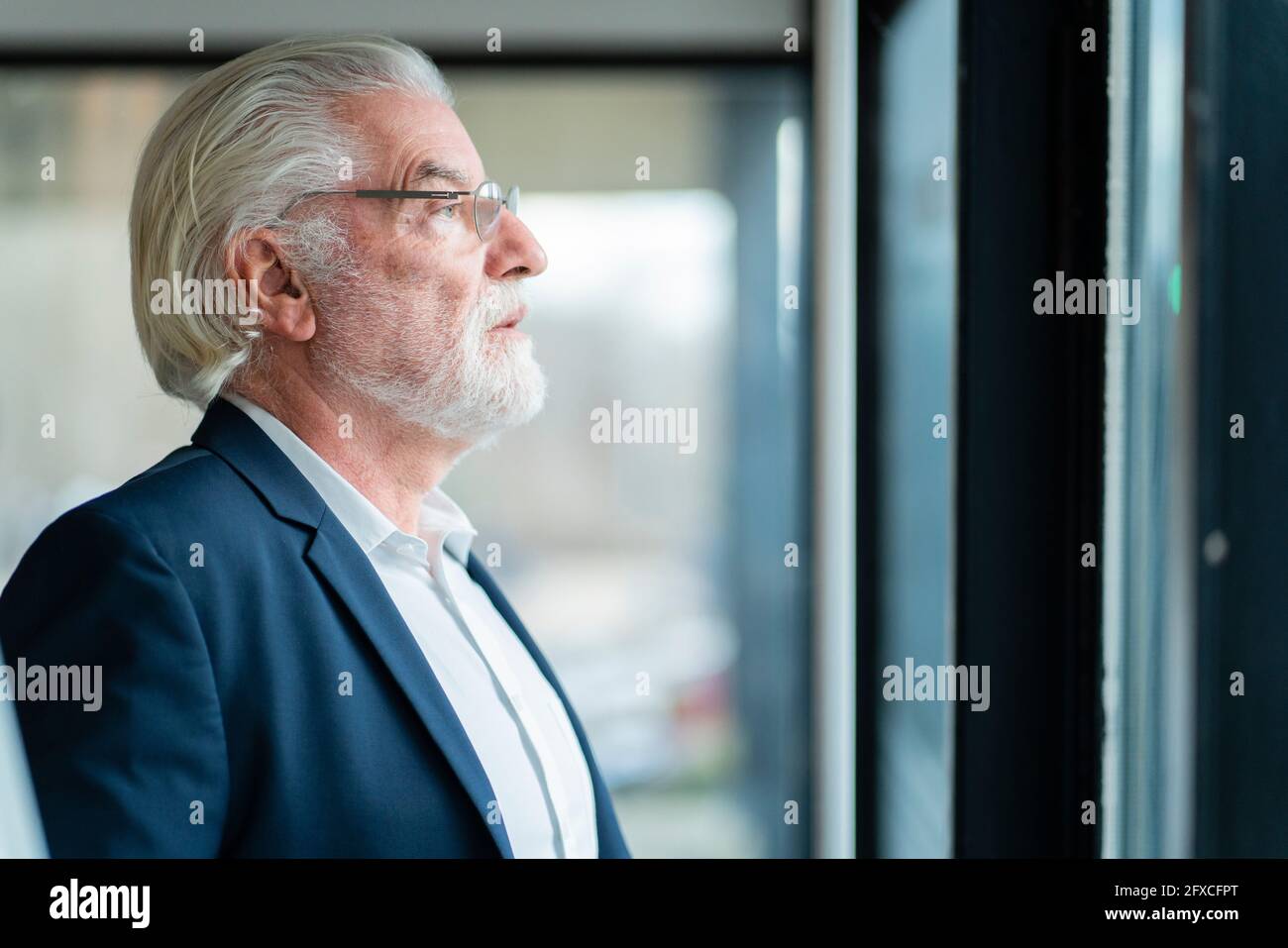 Leitender männlicher Unternehmer, der ins Büro schaut Stockfoto