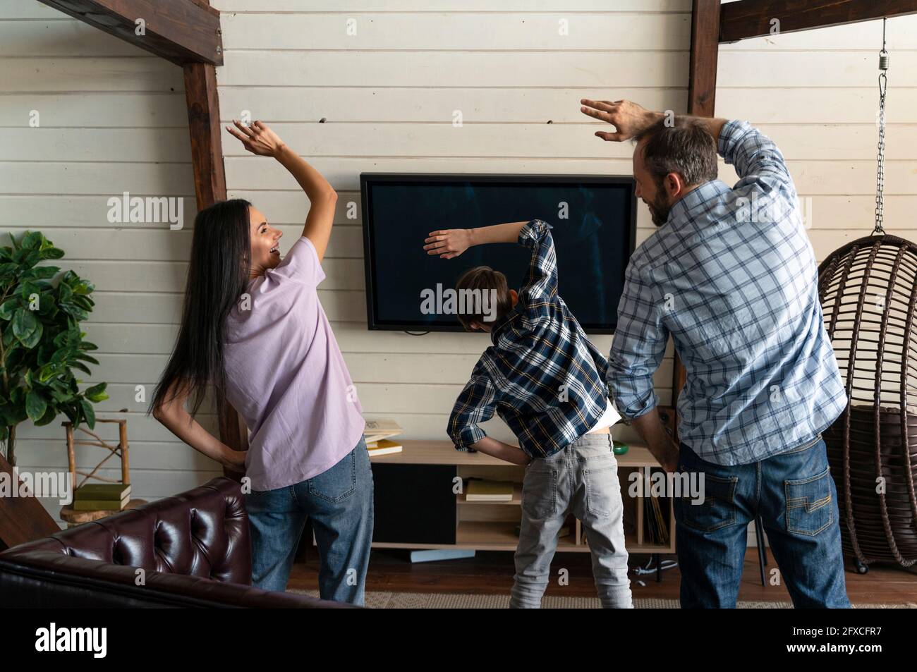 Vater und Mutter tanzen zu Hause mit dem Sohn Stockfoto