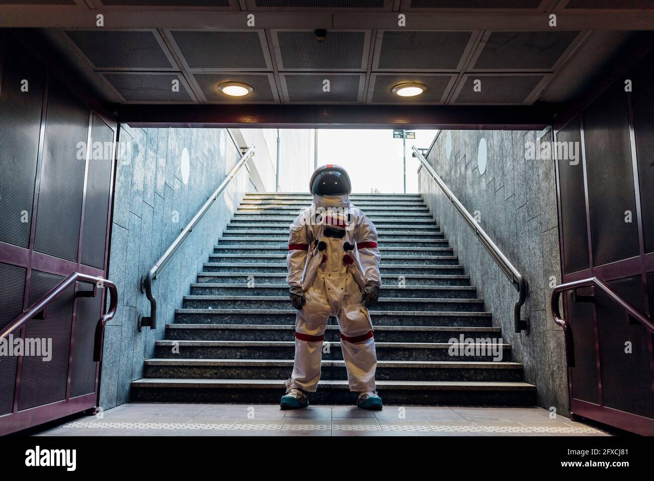 Männlicher Astronaut, der vor der Treppe steht Stockfoto