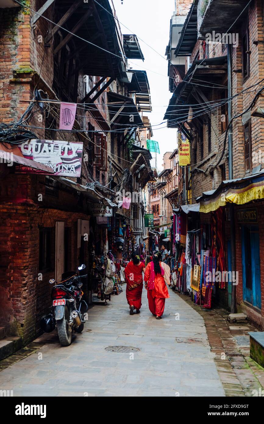 Ein nepalesisches Paar, das durch die Straßenmarktstraße in Bhaktapur, Nepal, läuft Stockfoto
