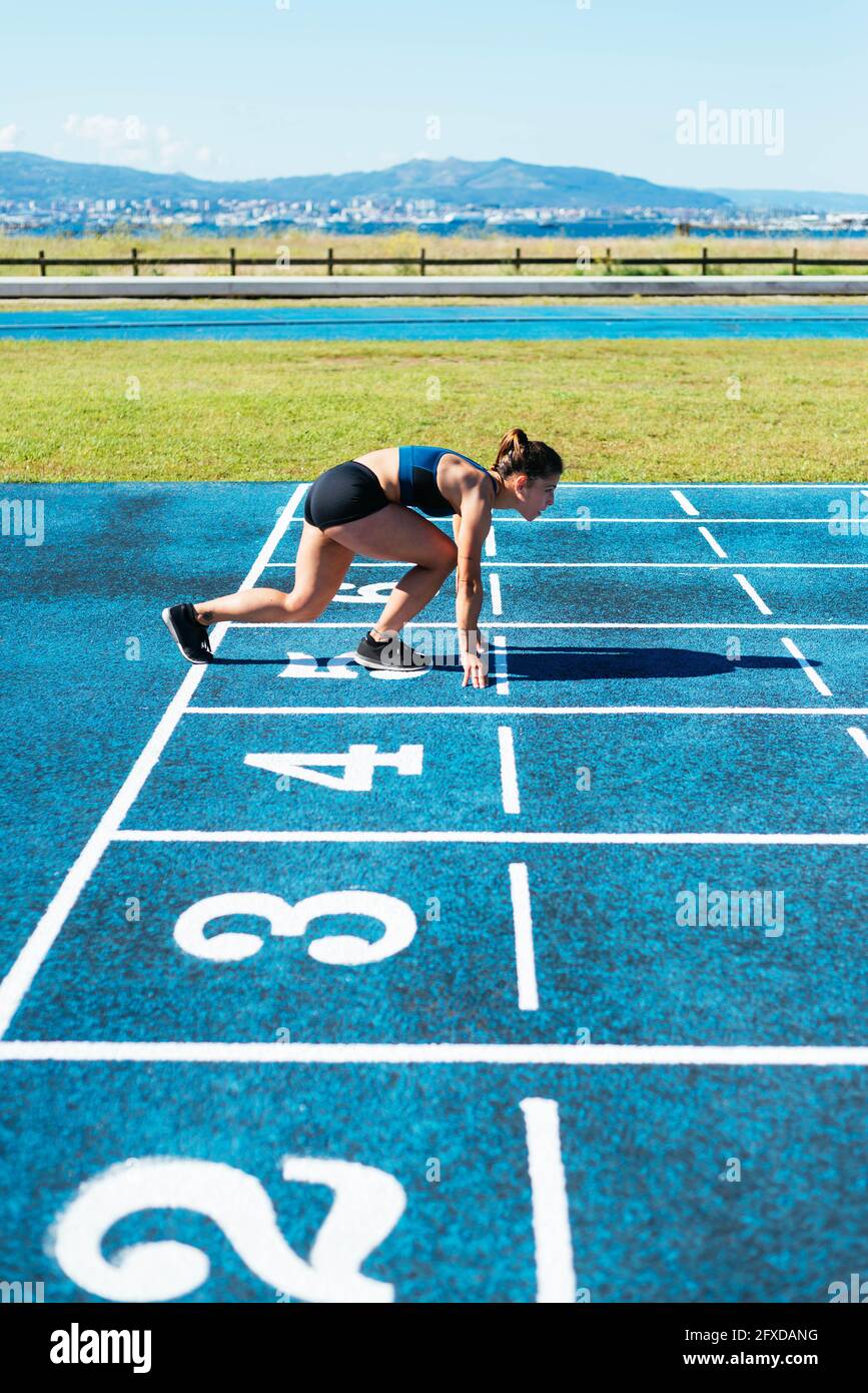 Athletin auf dem Lauffeld in Startposition Stockfoto