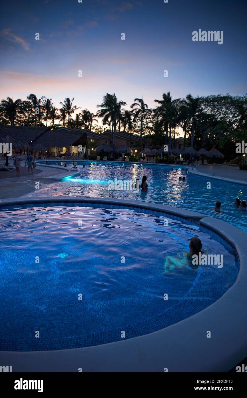 Menschen, die den Sonnenuntergang von einem Pool in Tamarindo, Costa Rica, Mittelamerika aus beobachten Stockfoto