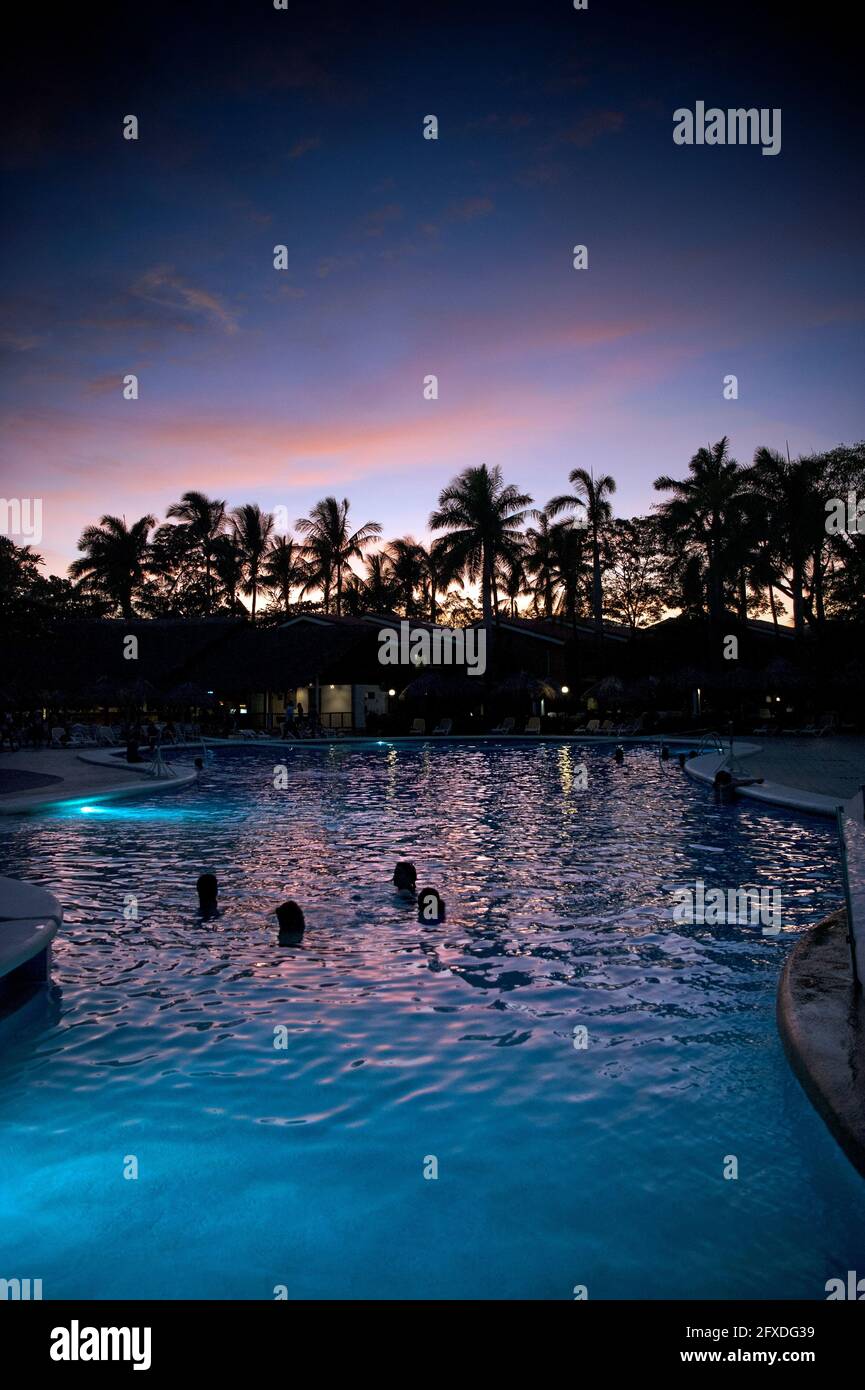 Menschen, die den Sonnenuntergang von einem Schwimmbad in einem Resort in Tamarindo, Costa Rica, Mittelamerika aus beobachten Stockfoto