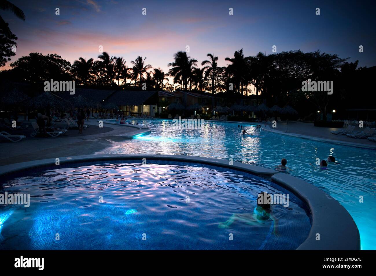Menschen, die den Sonnenuntergang von einem Pool in Tamarindo, Costa Rica, Mittelamerika aus beobachten Stockfoto