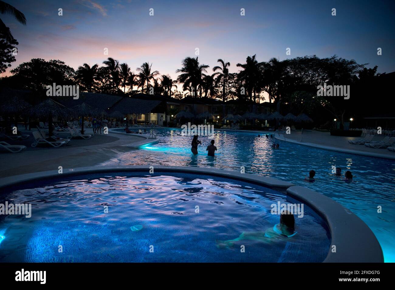 Menschen, die den Sonnenuntergang von einem Pool in Tamarindo, Costa Rica, Mittelamerika aus beobachten Stockfoto