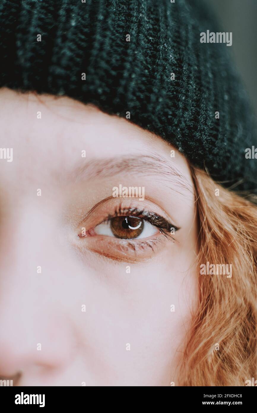 Vertikale Aufnahme der Hälfte des weiblichen Gesichts mit einem Auge und blonden Haaren Stockfoto