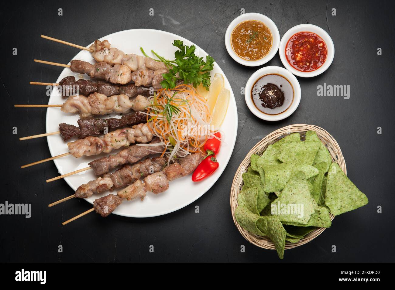 Gegrilltes Rindfleisch, Huhn und Schweinespieße in einem koreanischen Restaurant. Mit Pommes frites und heißen Dips mit Chilisauce. Stockfoto