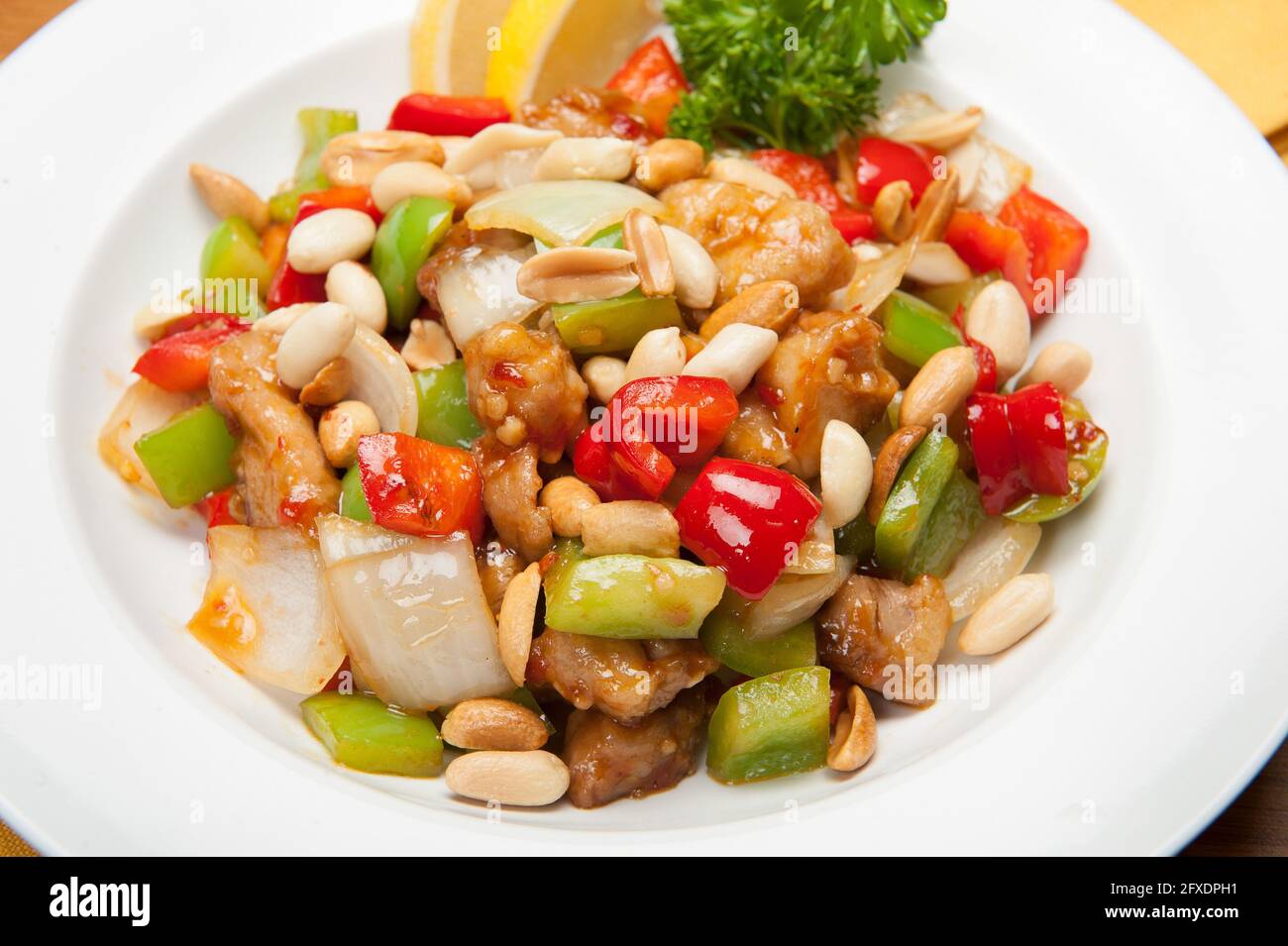 Asiatisches Huhn mit Erdnüssen, roten und grünen Paprika in einem koreanischen Restaurant. Stockfoto