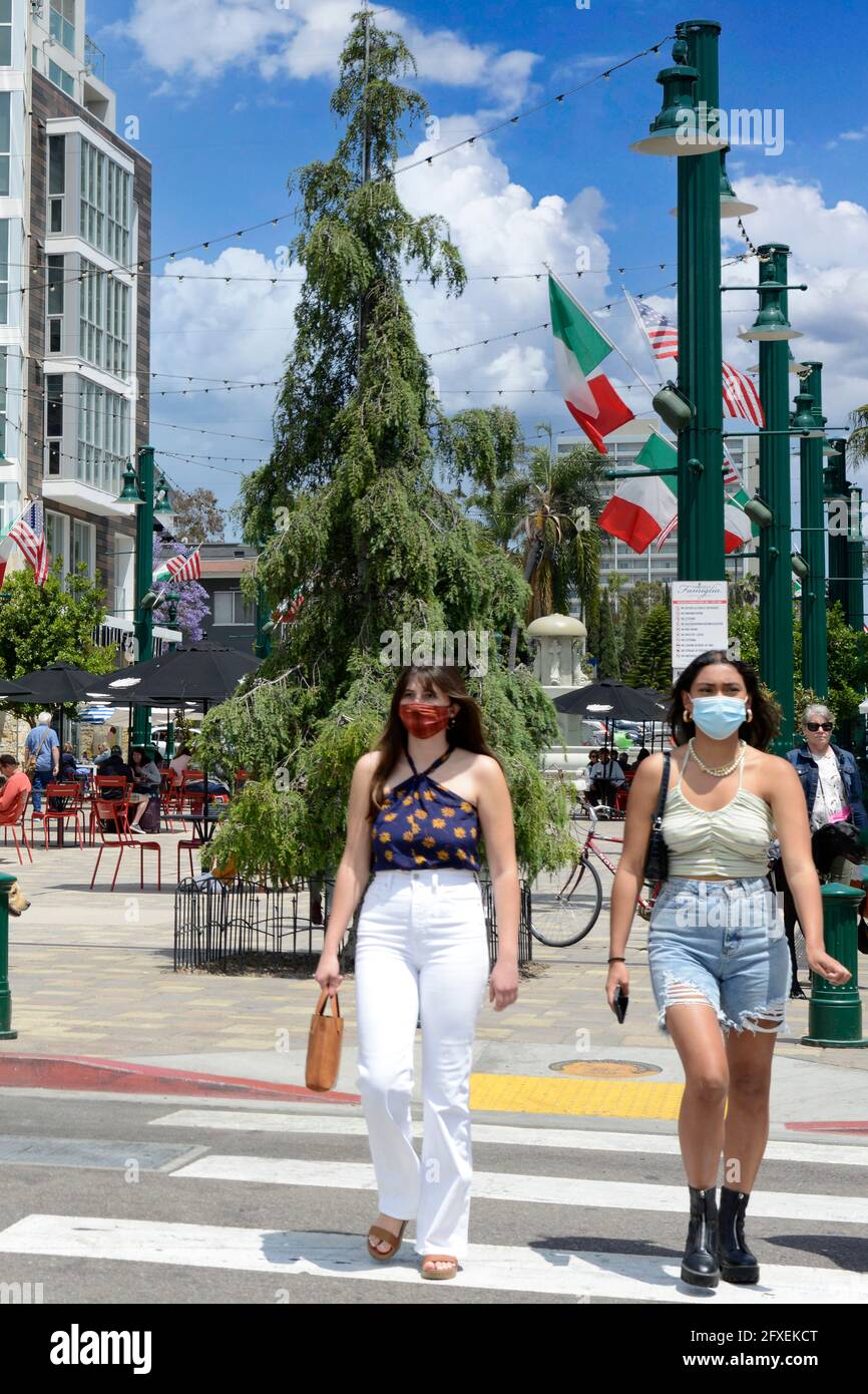 Junge Menschen, die Covid-Masken tragen, überqueren die W Date Street im Herzen des Viertels Little Italy in San Diego, Kalifornien Stockfoto