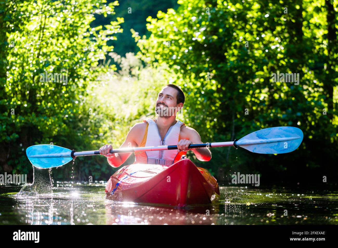 Mann am Fluss für Wassersport mit Kajak paddeln Stockfoto