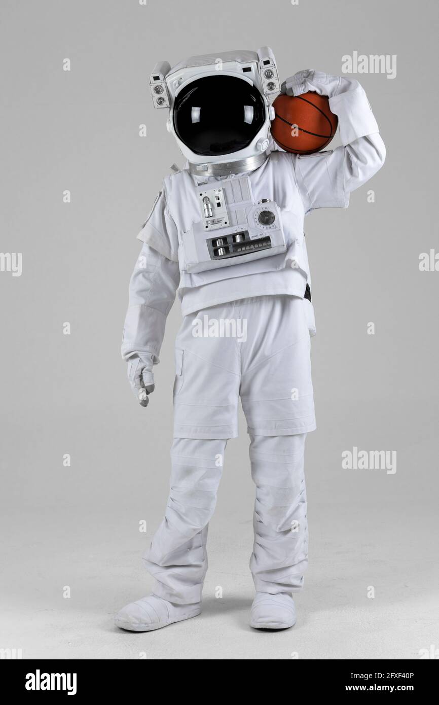 astronaut iwth Basketball Ball auf einer Schulter, weißer Hintergrund Stockfoto