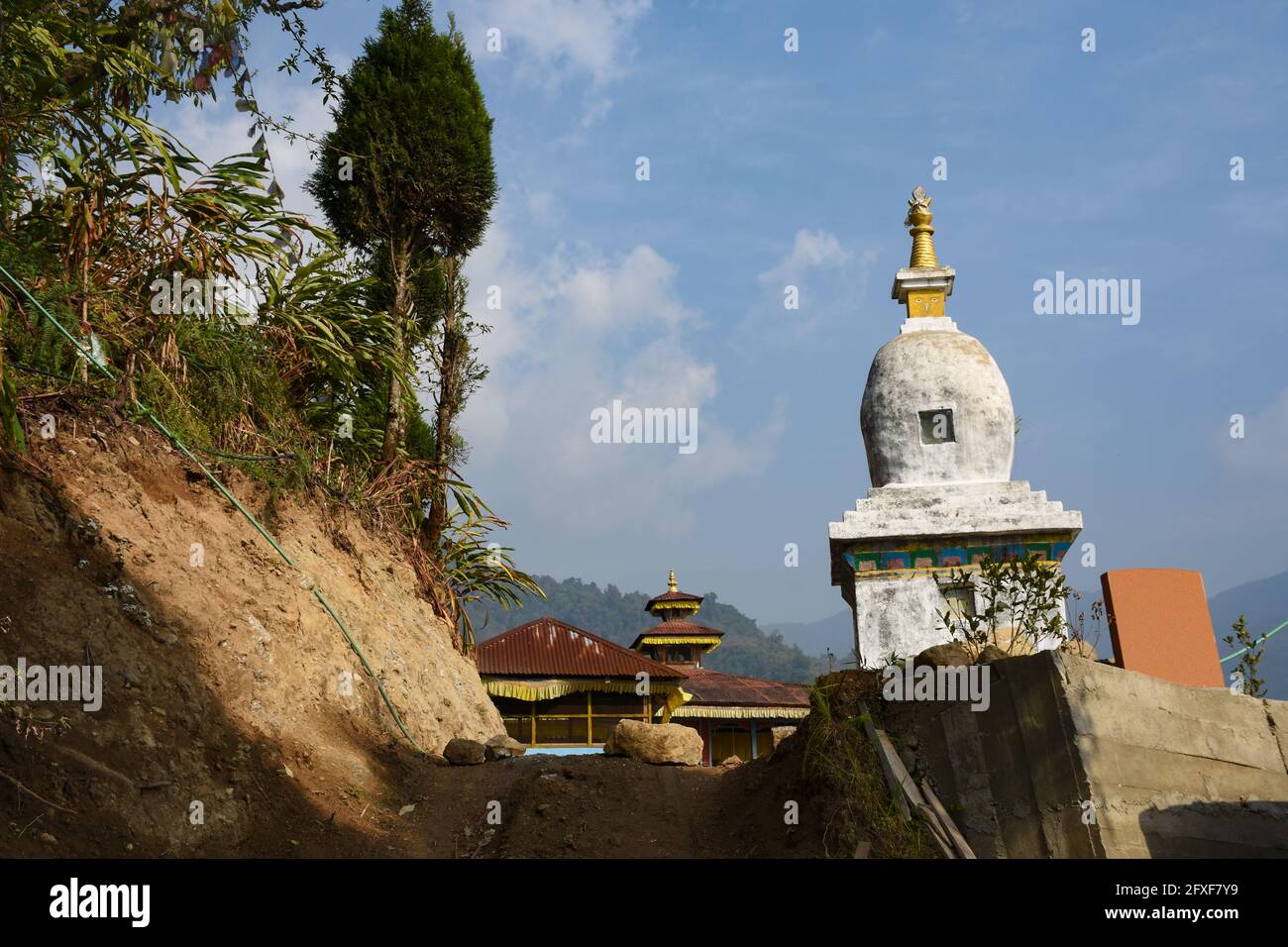 Exotische Ansicht von Gumpa mit Stupa, blau bewölkten Himmel und Kiefer in Todey, Kalimpong. Stockfoto