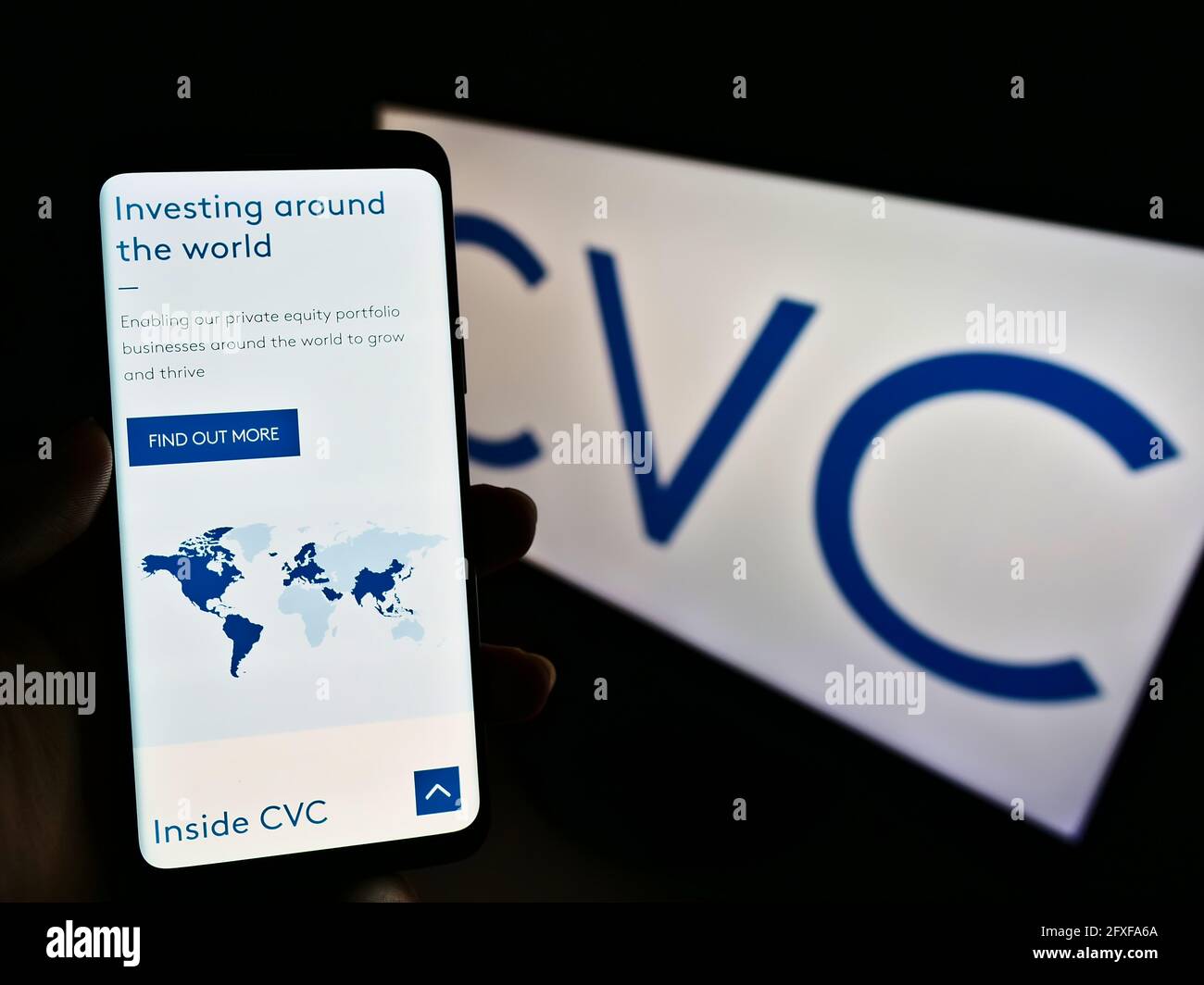Person, die Mobiltelefon mit Website der Private-Equity-Gesellschaft CVC Capital Partners auf dem Bildschirm vor dem Logo hält. Konzentrieren Sie sich auf die Mitte des Telefondisplays. Stockfoto
