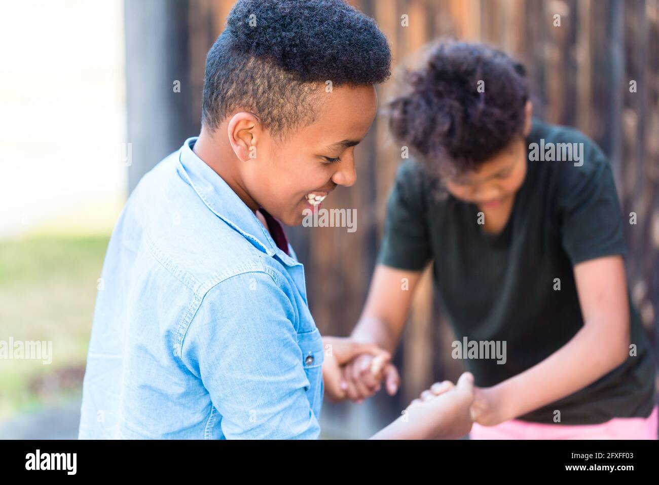 Bruder und Schwester, zwei schwarze Kinder, spielen auf Yard Stockfoto