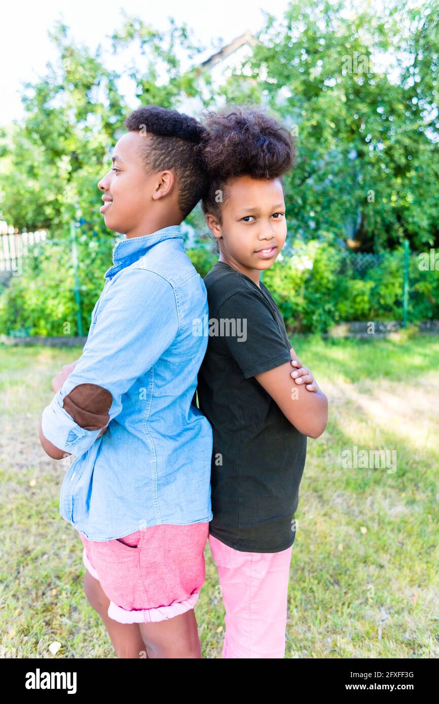 Bruder und Schwester, zwei schwarze Kinder, stehen Schulter an Schulter im Garten Stockfoto