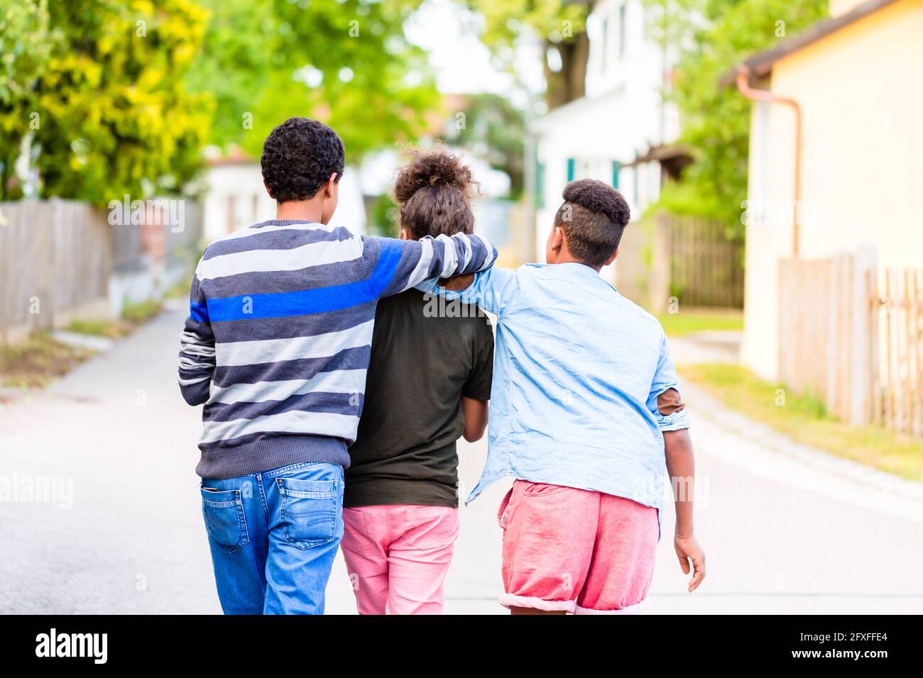 Geschwister, schwarze Mädchen und zwei Jungen, auf der Dorfstraße Stockfoto