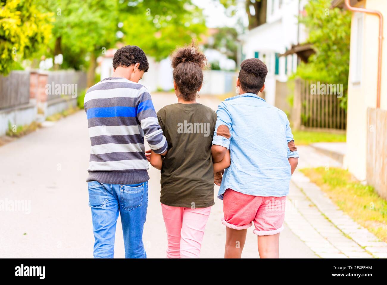 Geschwister, schwarze Mädchen und zwei Jungen, auf der Dorfstraße Stockfoto